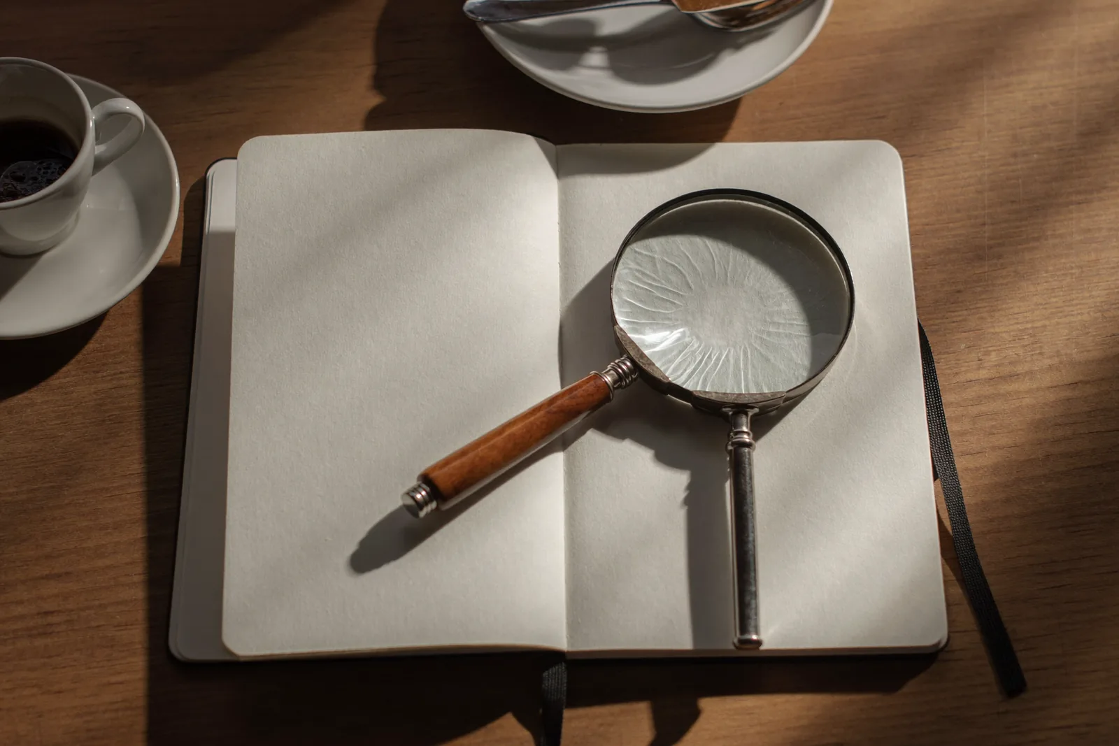 SEO Agentur Salzburg: 8 Merkmale, an denen du seriöse Anbieter erkennst 4 SEO Agentur Salzburg prüfen: Lupe auf leerem Notizbuch
