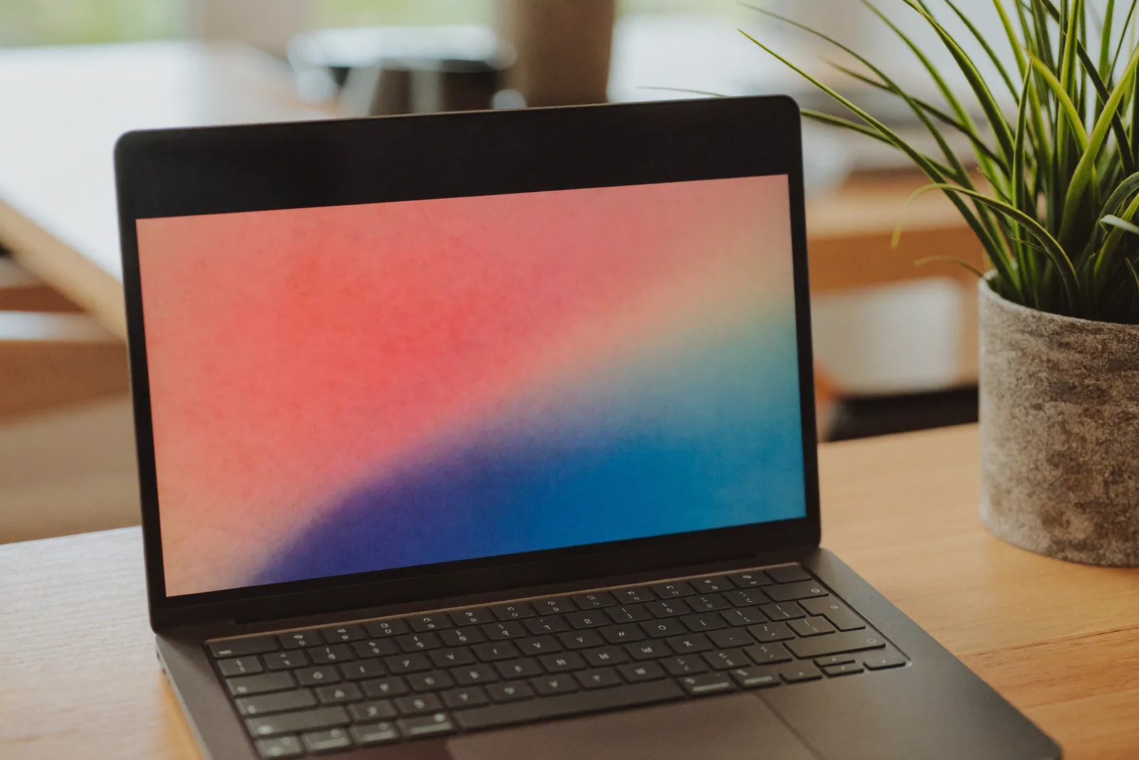 Webdesign Salzburg: Laptop mit Farbverlauf am Arbeitsplatz einer Webdesign-Agentur